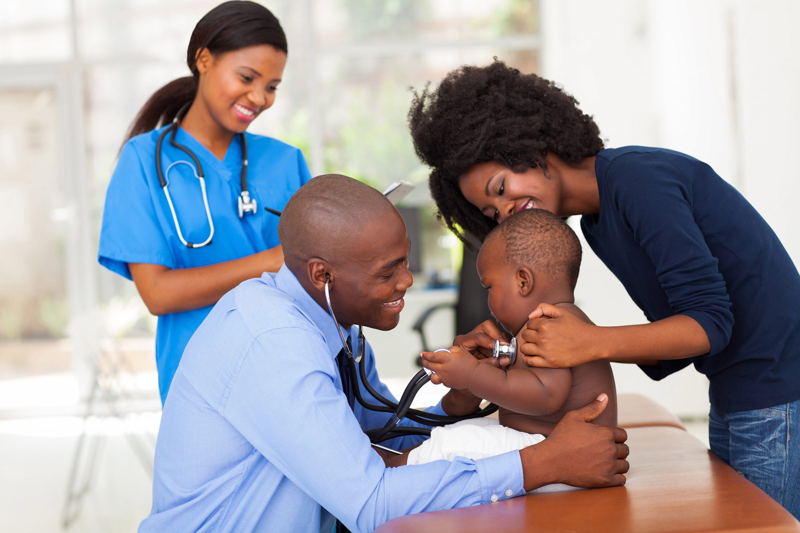 a doctor checking a baby accompanied by his mother and nurse